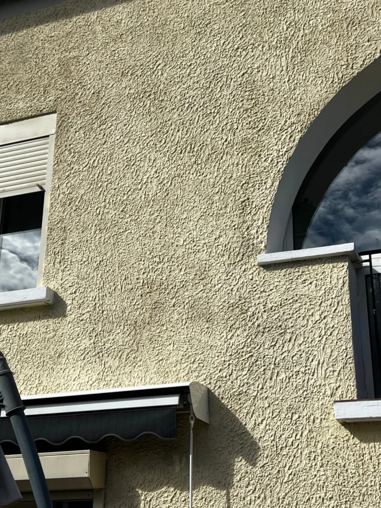 Traitement et nettoyage d'un crépi extérieur ancien usé par le temps et la pollution à Gardanne.